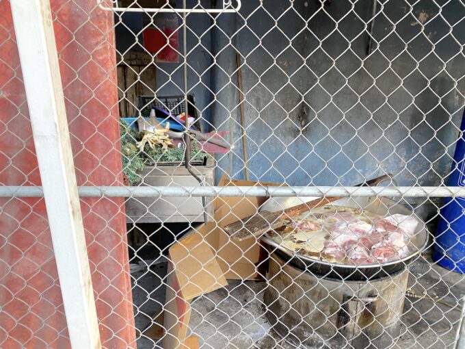 店の裏で肉を煮込む